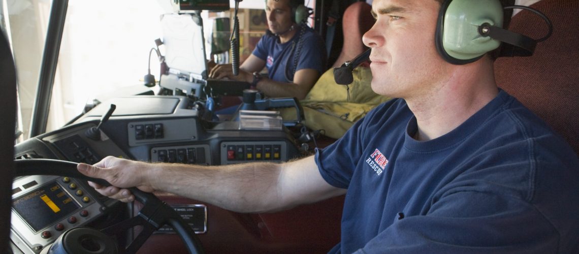 A firefighter driving a fire engine A firefighter driving a fire engine